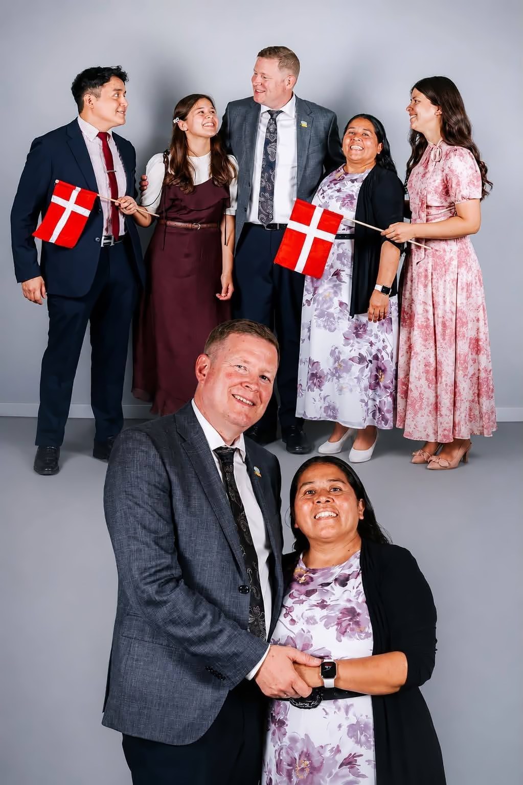 La familia pastoral sonríe con banderitas danesas
